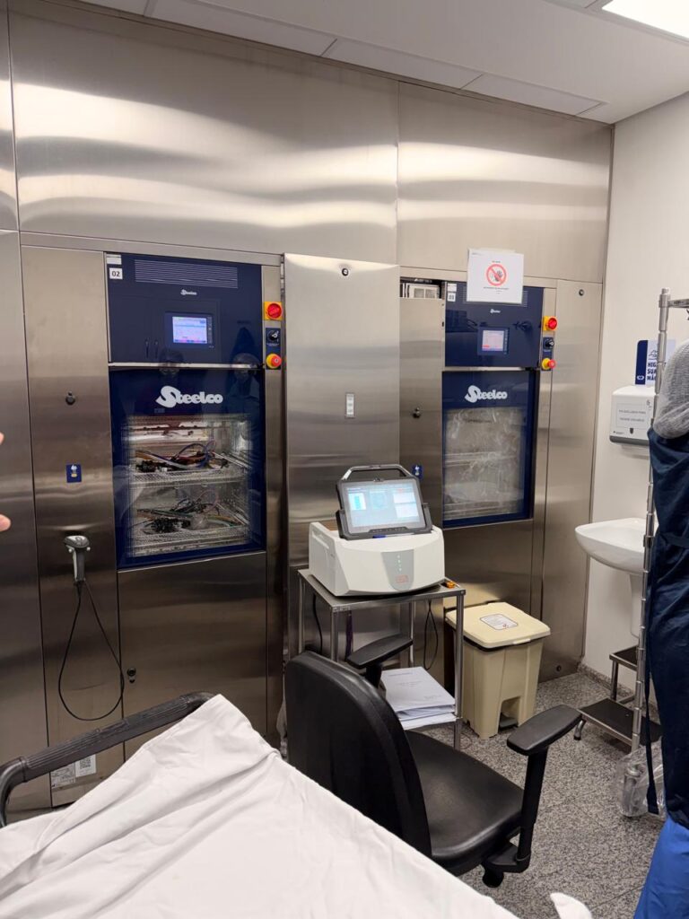 Lavadoras termodesinfectoras em qualificação térmica, com registrador de dados ao lado, em área de reprocessamento hospitalar
