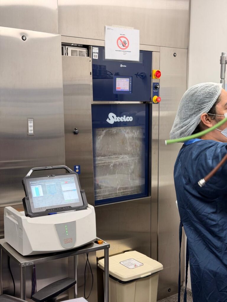 Profissional acompanha a qualificação térmica de uma lavadora termodesinfectora com registrador de dados
