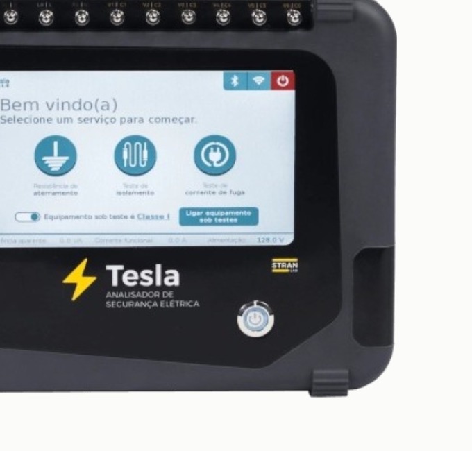 Detalle del analizador Tesla de Arkmeds encendido, con servicios de tierra, aislamiento y corriente de fuga en la pantalla.